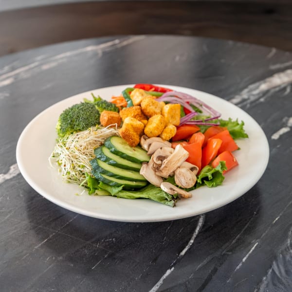 Bell the Cat's colorful salad with crispy tofu, broccoli, cucumber, tomatoes, mushrooms, and sprouts.